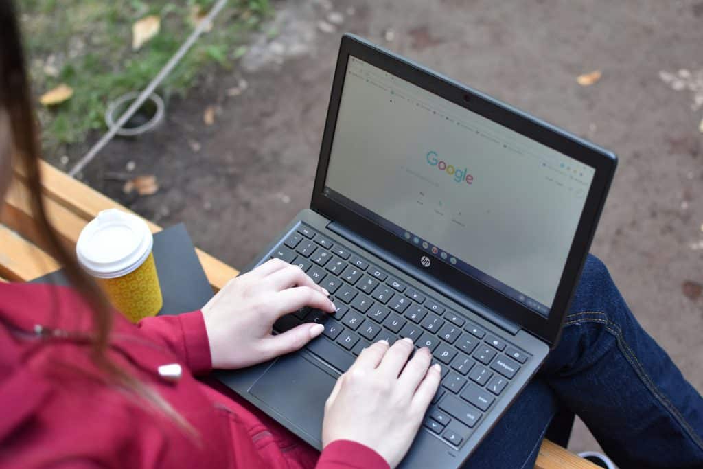 A young woman doing research, deciding which one between Brown vs Cornell to apply to for college.