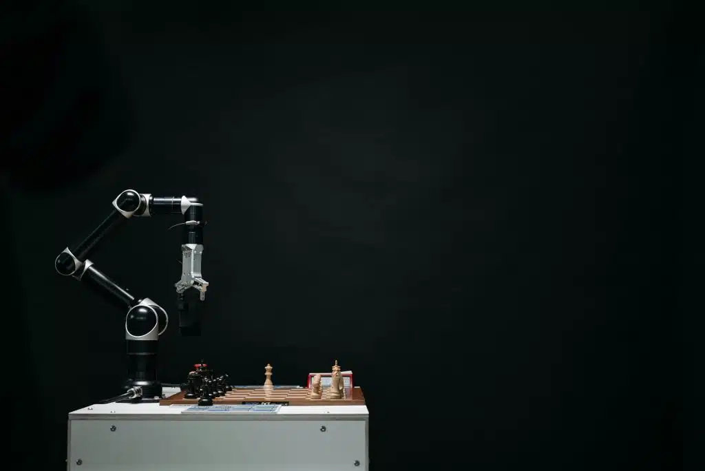 A robotic arm plays chess on a board, symbolizing robotics internships for high school students.