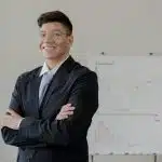 Confident college student in a business setting with charts, representing the best colleges for economics and career-focused academic paths