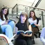 Students holding books reading checking UIUC vs USC