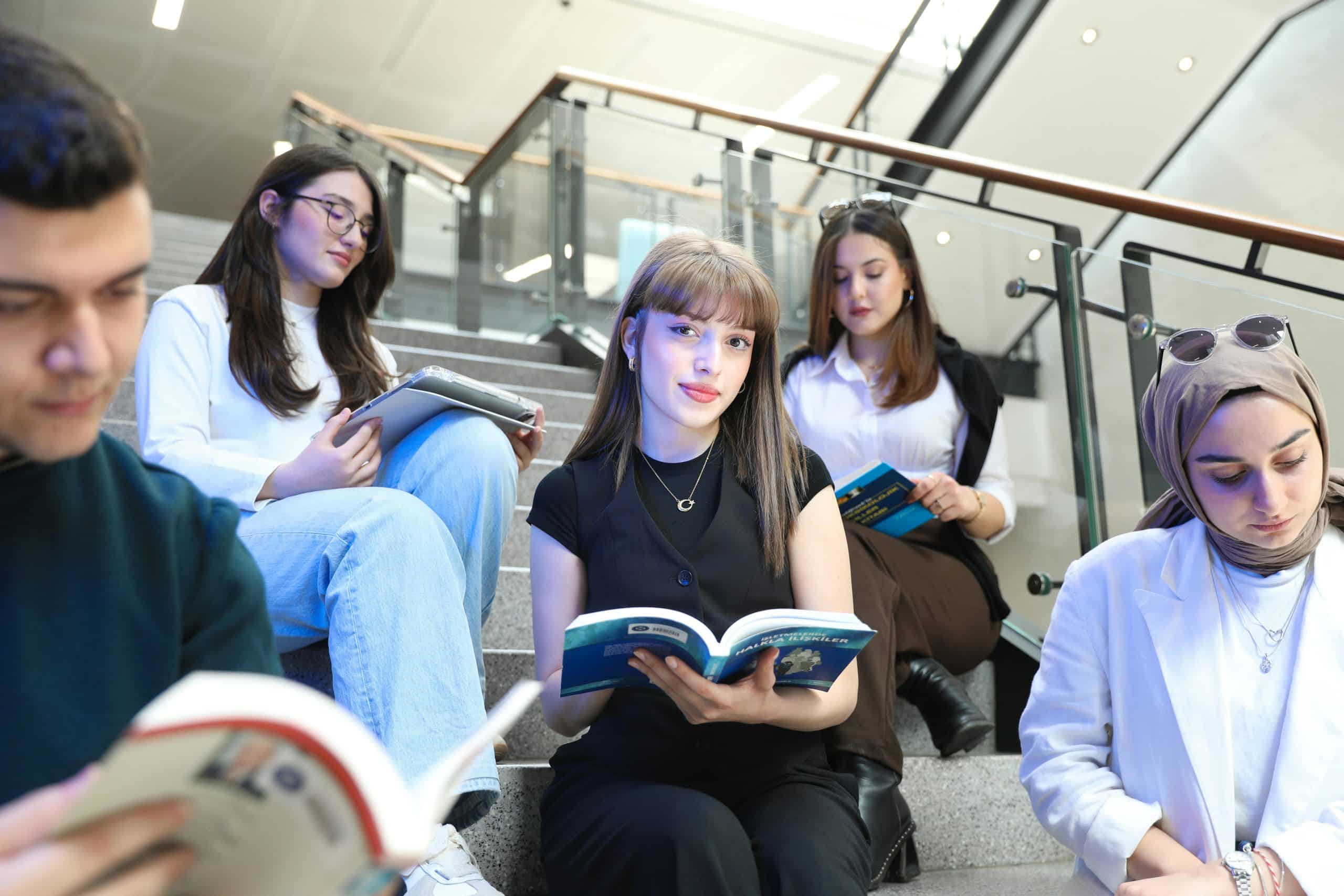Students holding books reading checking UIUC vs USC