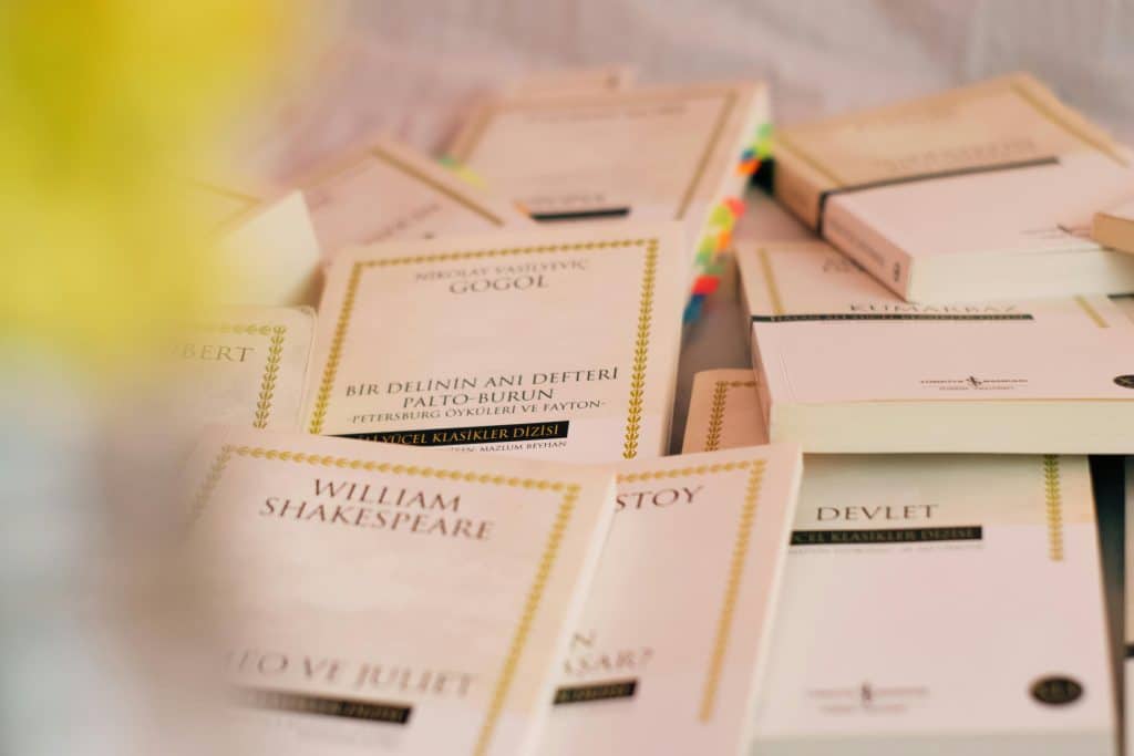 Scattered classic literature paperbacks by Shakespeare, Gogol, and Tolstoy, ideal for students at the best colleges for literature