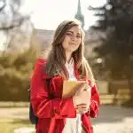 High school student holding books on campus, exploring opportunities for high school scholarships