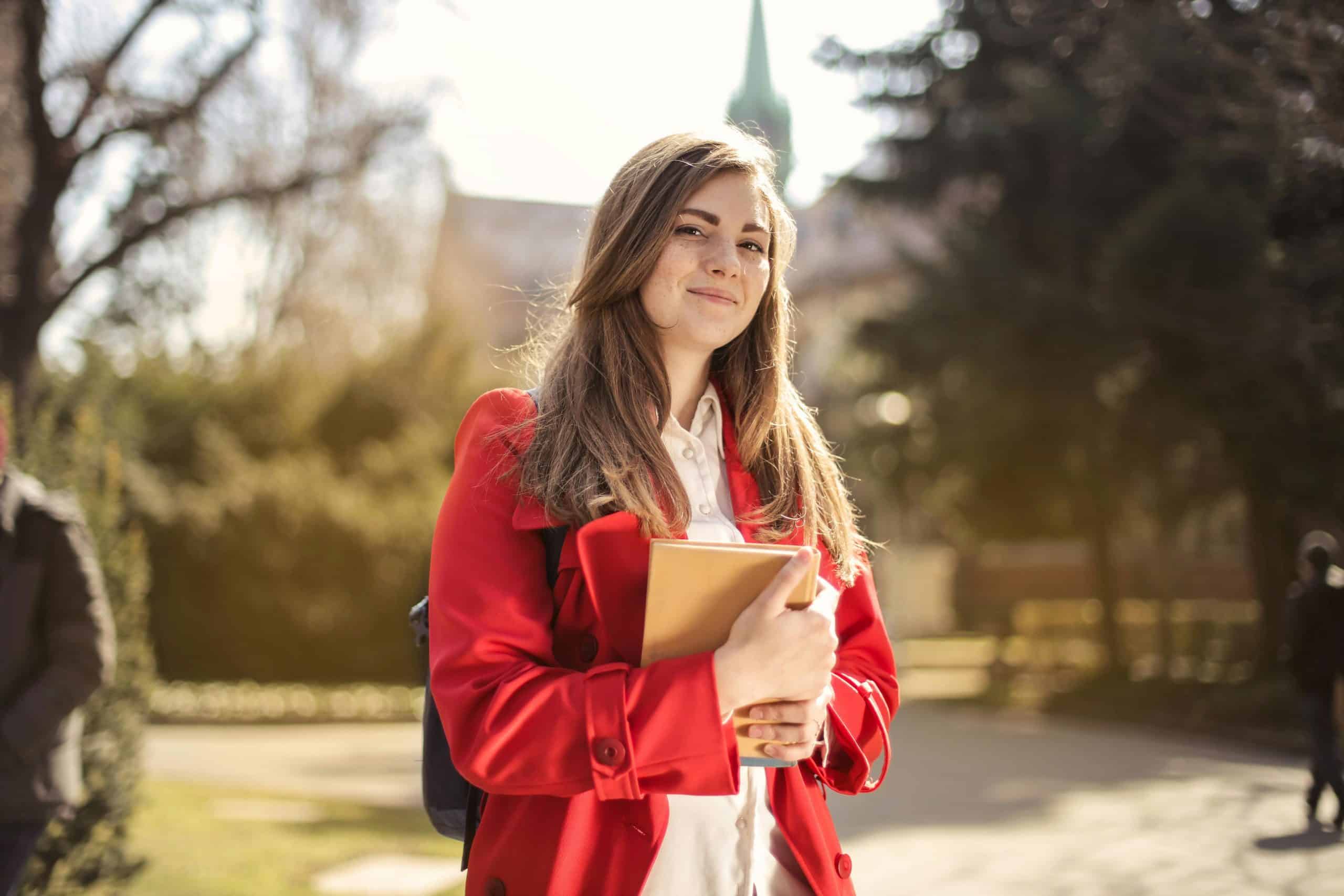 High school student holding books on campus, exploring opportunities for high school scholarships