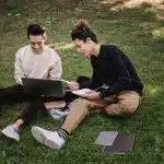 Two students sitting down writing their own letter of intent for college