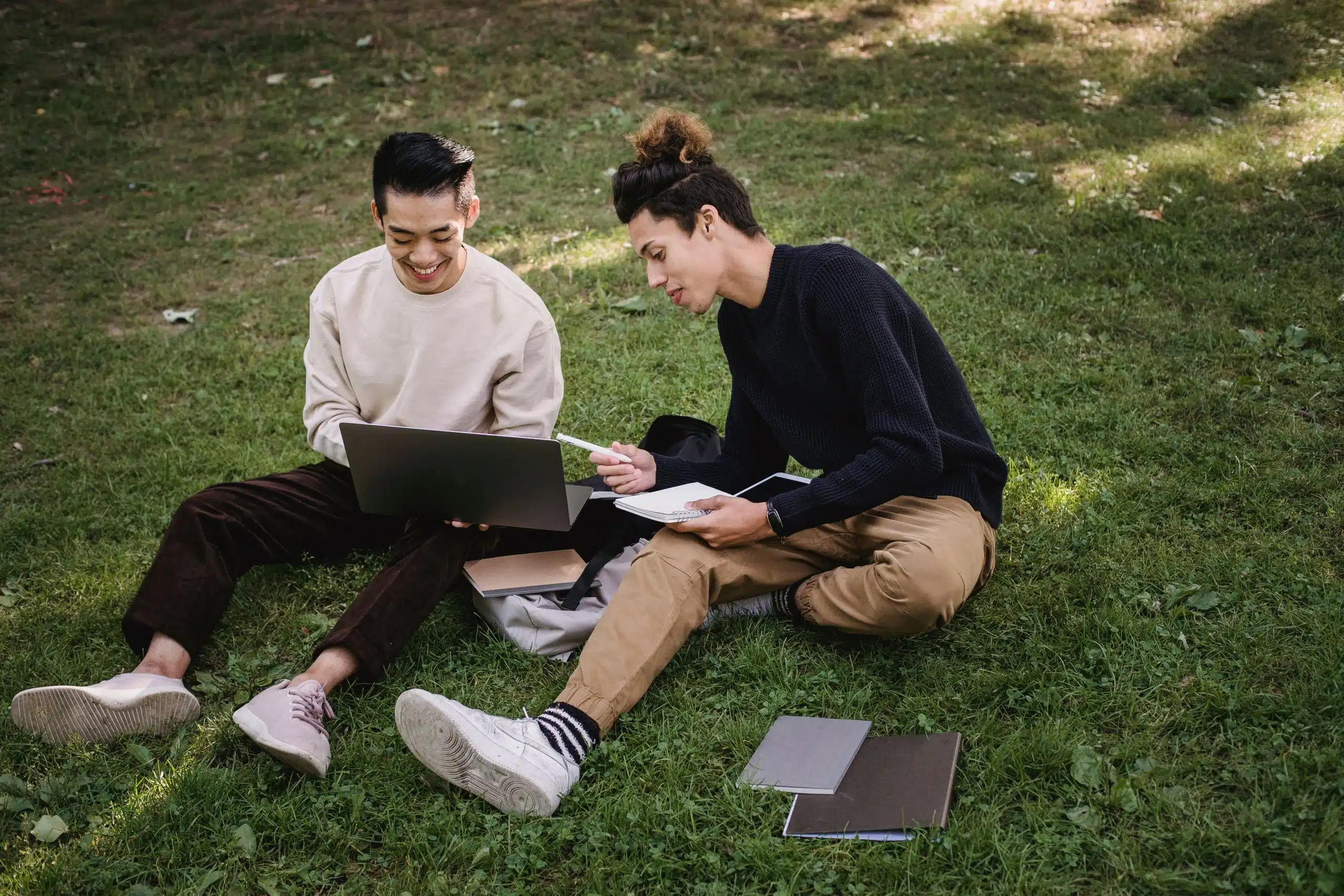 Two students sitting down writing their own letter of intent for college