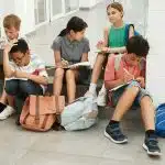 Students collaborating and studying together while working through some of the hardest high school classes in a school hallway