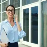 Young professional reviewing MBA admissions options and preparing for the GMAT vs GRE decision outside an office building