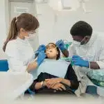 Dental students treating a patient in a clinical training setting at one of the best dental schools in the US.