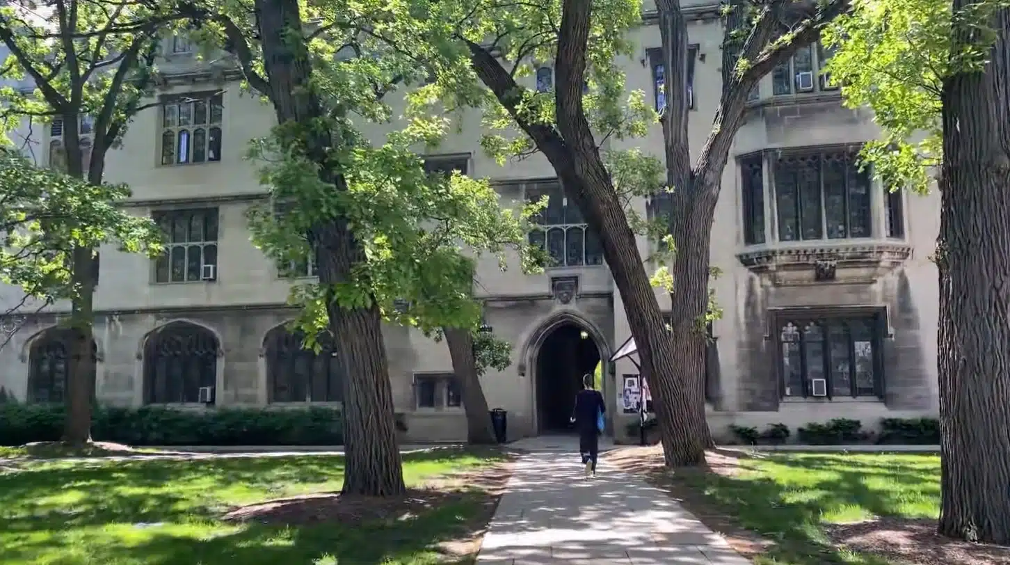 woman in black walking in uchicago campus