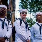 Three U.S. Navy sailors in uniform stand together outdoors, representing the military environment and service commitment associated with the Naval Academy acceptance rate and admissions process.