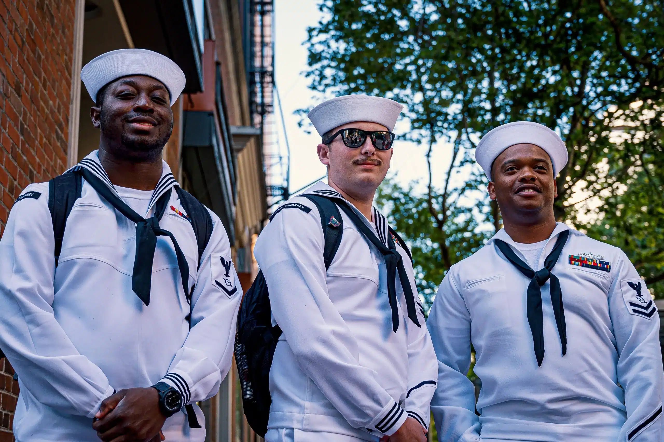 Three U.S. Navy sailors in uniform stand together outdoors, representing the military environment and service commitment associated with the Naval Academy acceptance rate and admissions process.