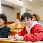 student in red jacket smiling after learning about the bowdoin acceptance rate